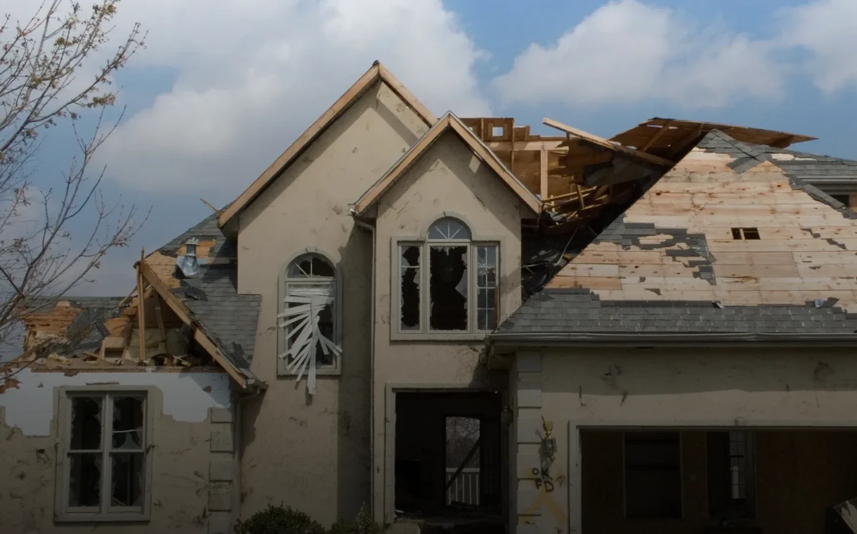 Storm-damaged home under cloudy sky